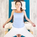 "Yoga practitioner reclining in Bound Angle Pose with soles together."
