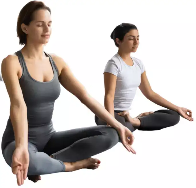"Two yoga practitioners seated in meditation pose with legs crossed."