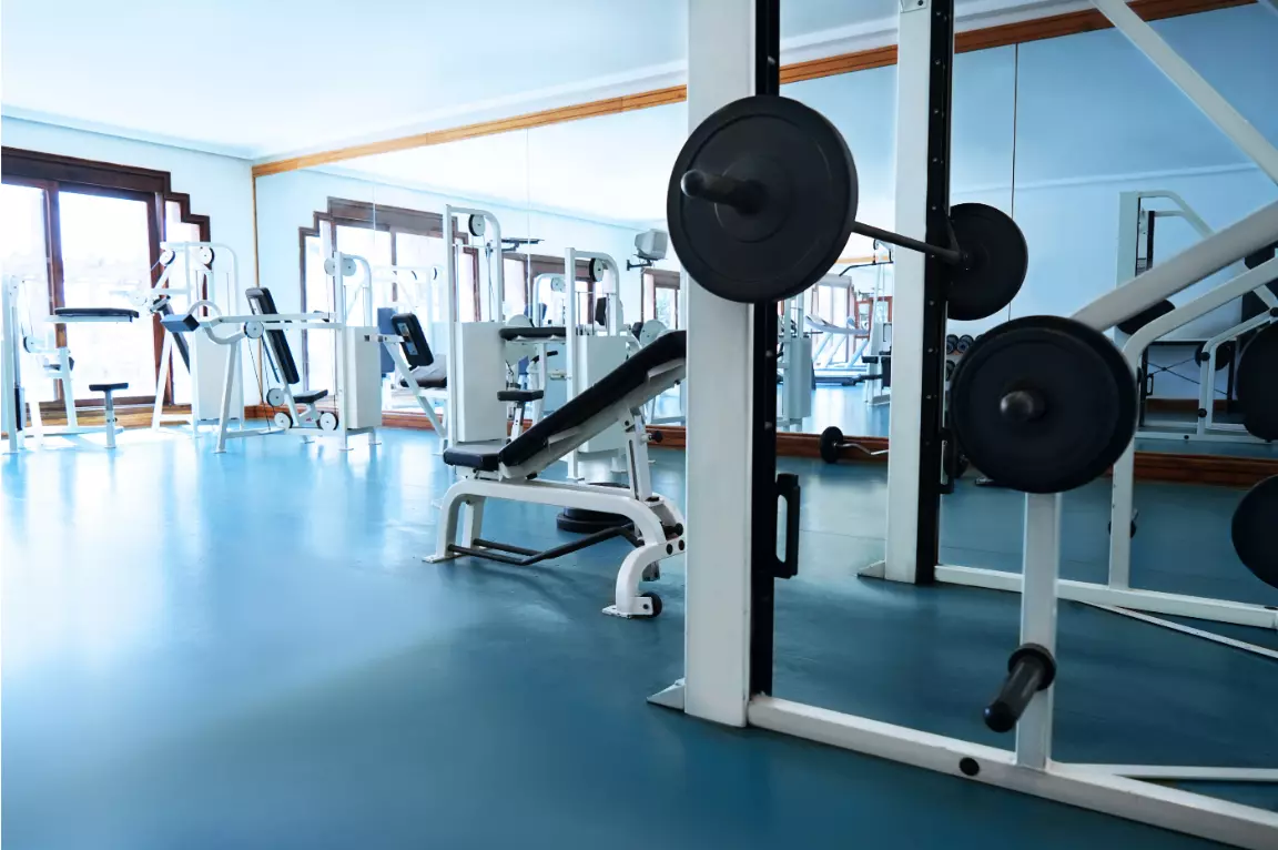 People working out in a Planet Fitness gym with exercise machines and weights.