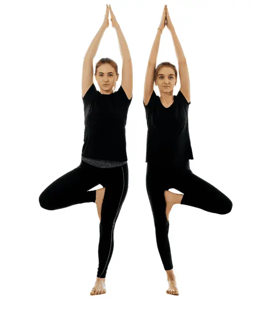 Yoga pose photo of woman in Tree Pose standing on one foot with arms raised