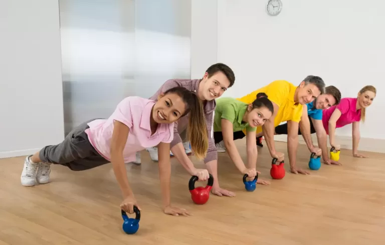 A group of male female friends exercising together and laughing